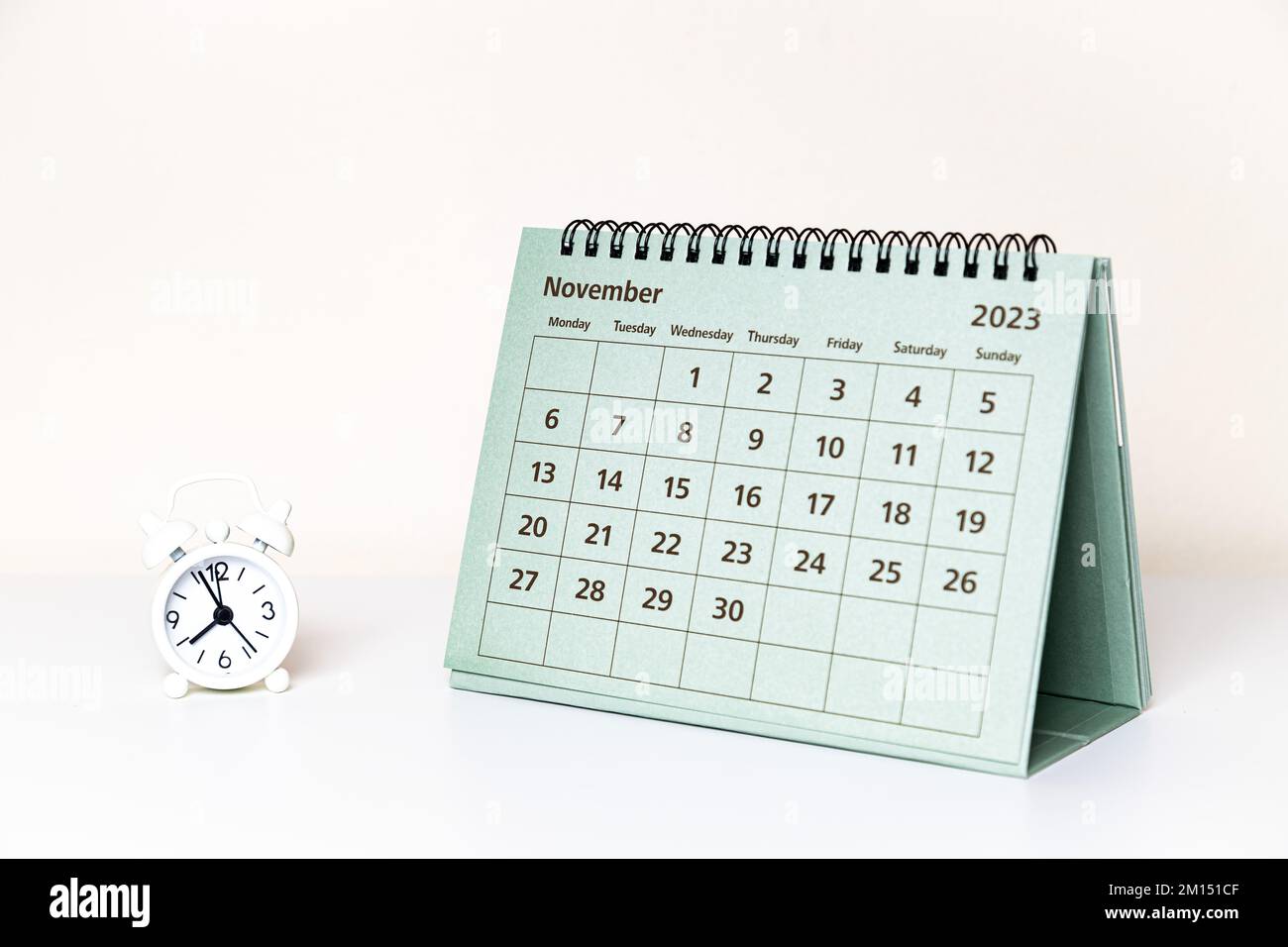Calendario di novembre 2023 e piccolo orologio su sfondo bianco isolato Foto Stock