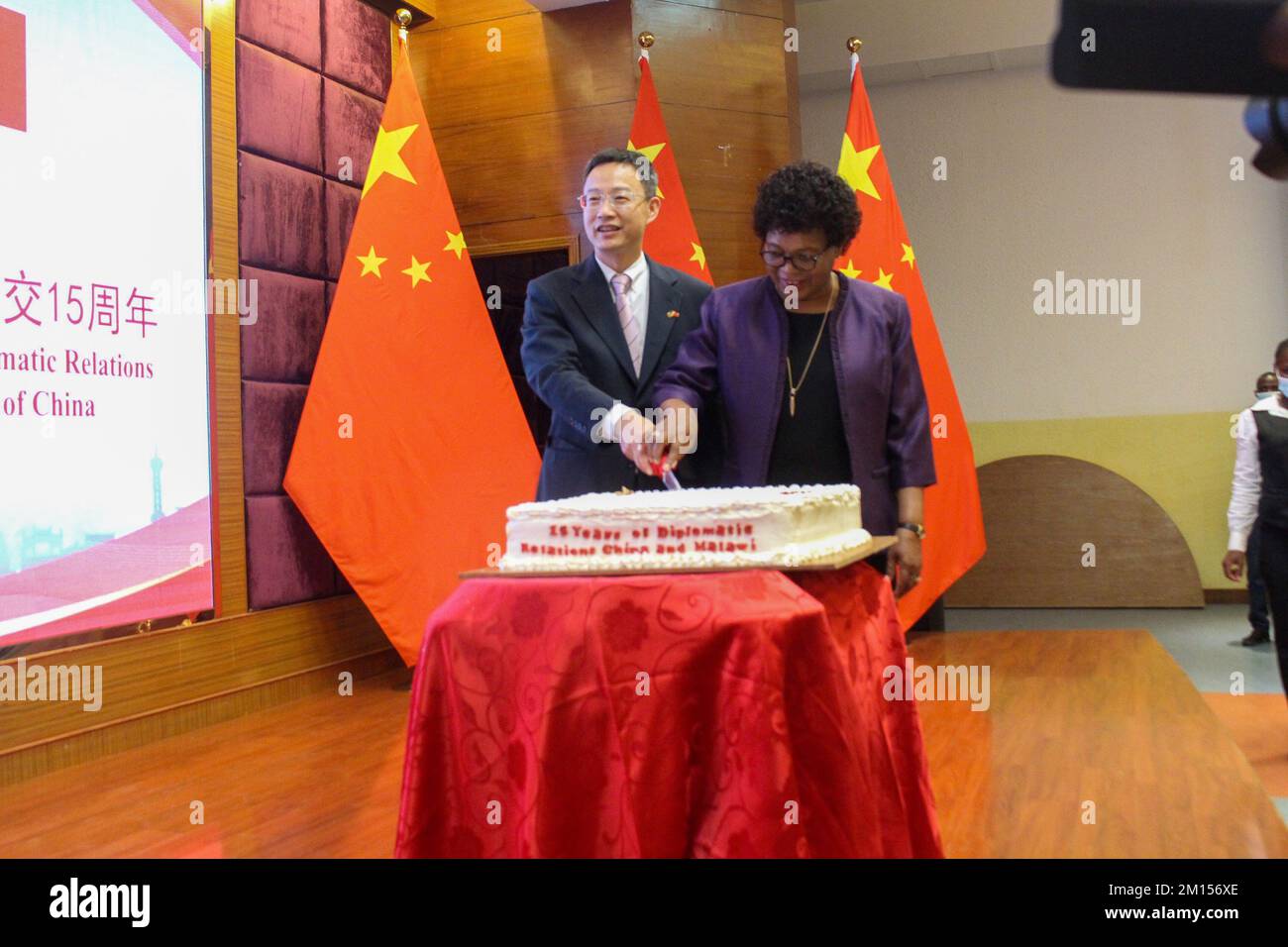 Lilongwe, Malawi. 8th Dec, 2022. L Ambasciatore cinese in Malawi Long Zhou (L) e il Ministro degli Esteri del Malawi Nancy Tembo hanno tagliato insieme una torta durante la celebrazione di 15 anni di legami bilaterali tra i due Paesi a Lilongwe, Malawi, 8 dicembre 2022. I governi cinese e malawiano hanno riaffermato il loro impegno a rafforzare le loro relazioni bilaterali a vantaggio reciproco dei due paesi. Credit: Joseph Mizere/Xinhua/Alamy Live News Foto Stock