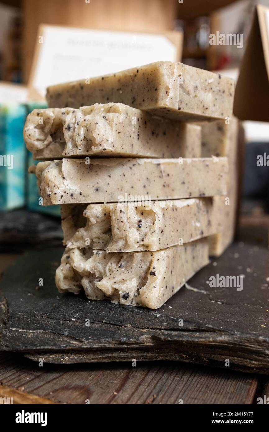 Molte barrette di sapone beige fatto a mano per l'igiene posto su tavola di legno in officina Foto Stock