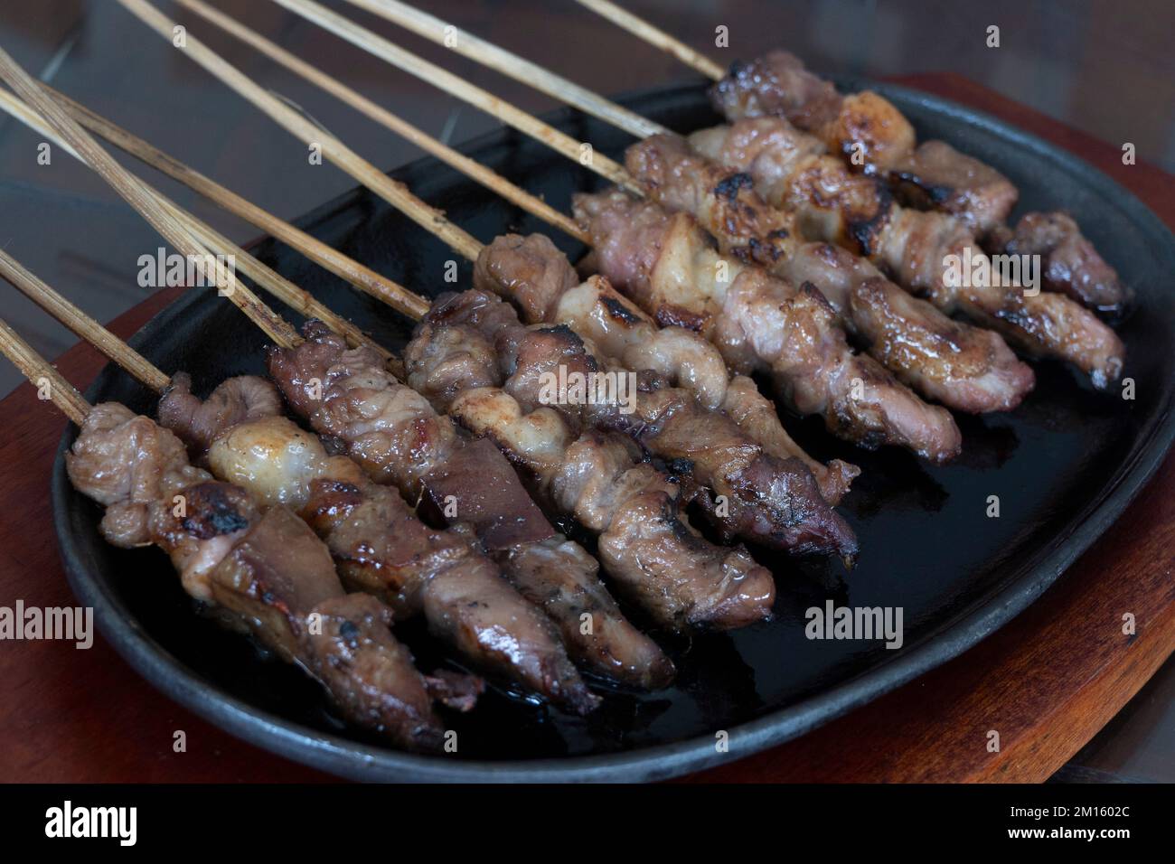 Spiedini di satay di agnello indonesiano serviti su piastra calda di ferro Foto Stock