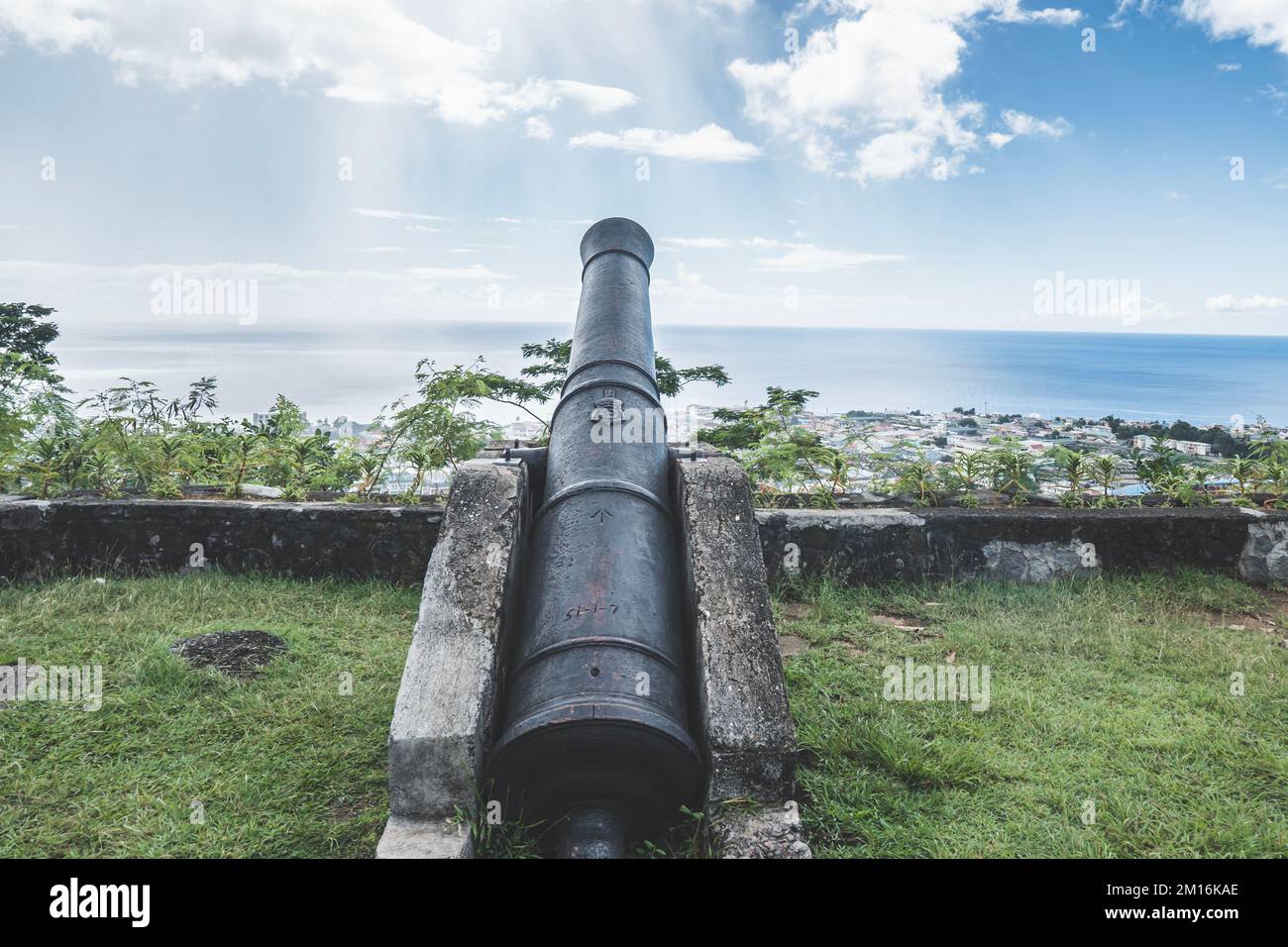 Vecchio cannone di ferro nero d'epoca di fronte all'Oceano Atlantico nella capitale di Dominica, Roseau Foto Stock