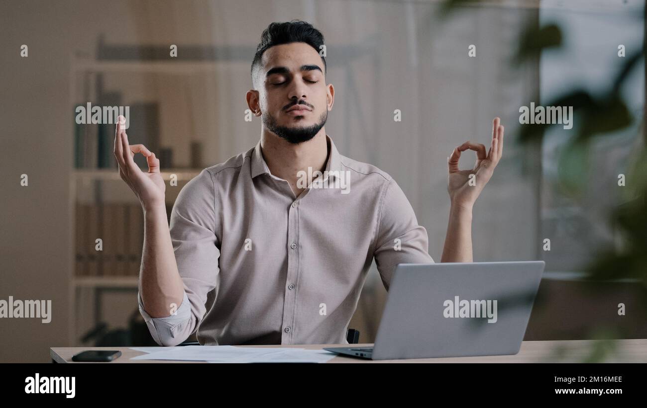 Calma uomo d'affari arabo professionale occhi lavoratore chiuso prendendo pausa meditating sul lavoro scrivania ignorando stress respirazione per la mente pacifica maschio boss d Foto Stock