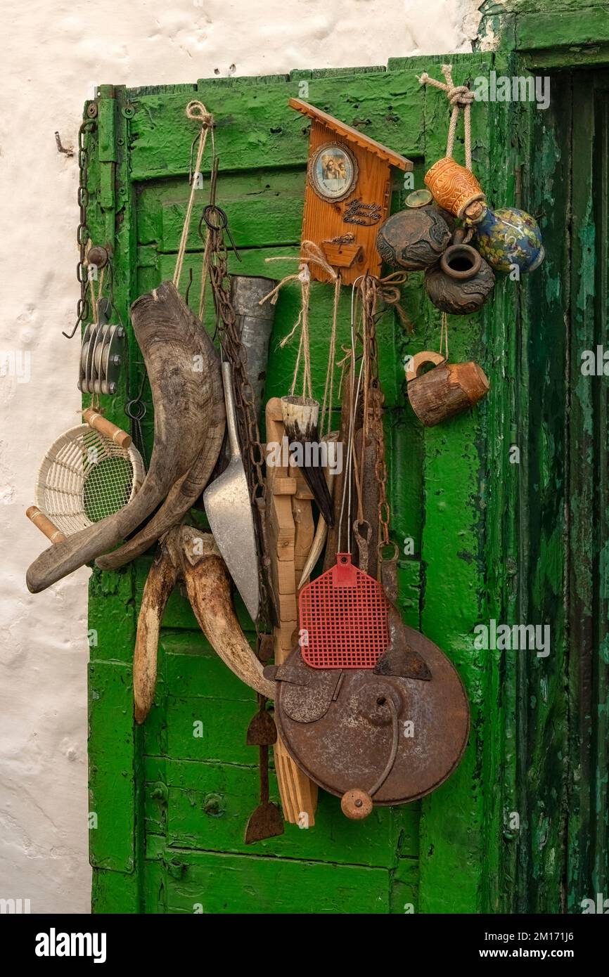 OSTUNI, ITALIA - 18 OTTOBRE 2022: Attrezzi e attrezzature vintage appesi alla porta del centro storico Foto Stock