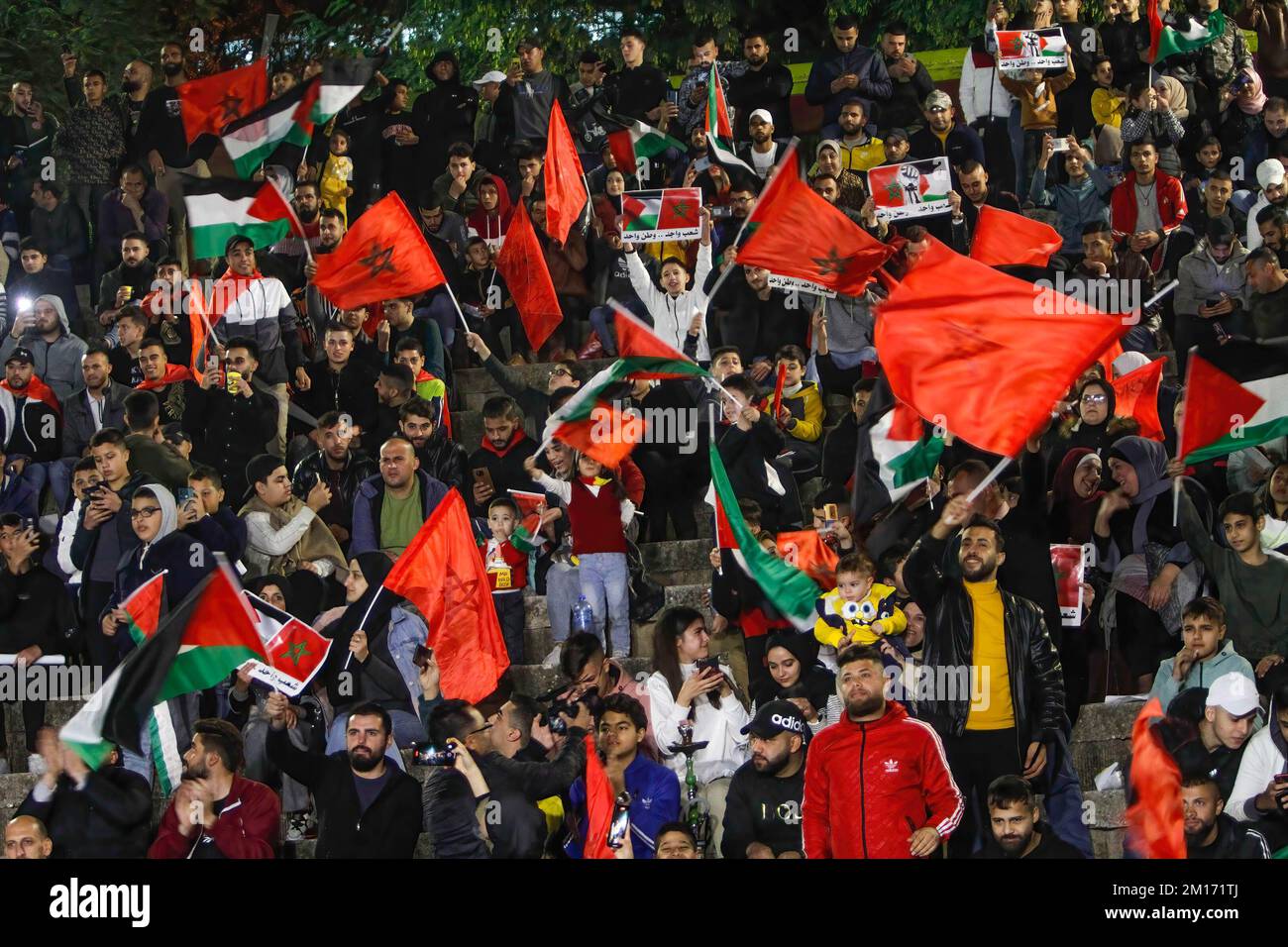 I sostenitori palestinesi della nazionale di calcio del Marocco celebrano nella città occupata di Nablus in Cisgiordania, segnando il traguardo di apertura durante la partita di calcio della Coppa del mondo del Qatar 2022 tra Marocco e Portogallo. Foto Stock