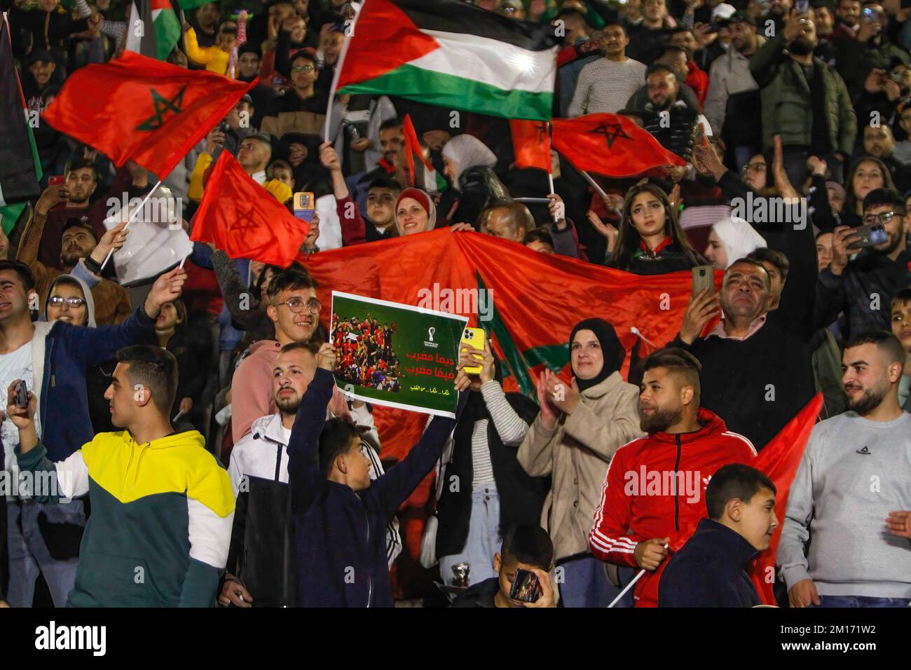 I sostenitori palestinesi della nazionale di calcio del Marocco celebrano nella città occupata di Nablus in Cisgiordania, segnando il traguardo di apertura durante la partita di calcio della Coppa del mondo del Qatar 2022 tra Marocco e Portogallo. Foto Stock