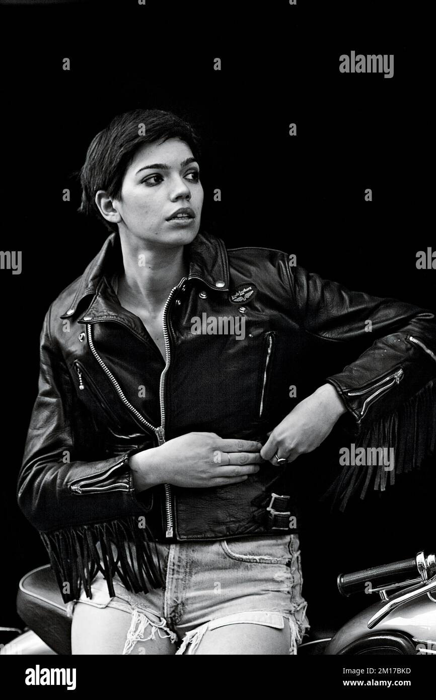 Bella motociclista femminile che indossa una giacca in pelle con nappine . Foto Stock
