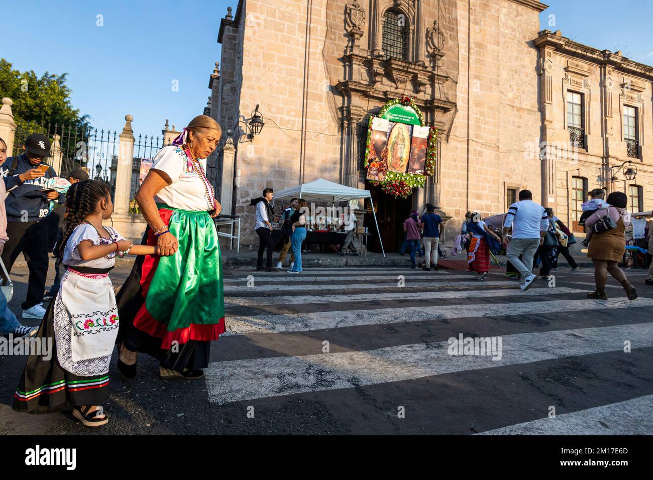 Morelia, Messico, 10 dicembre 2022, Una nonna e sua nipote arrivano al tempio durante il giorno delle celebrazioni della Vergine di Guadalupe. Milioni di messicani di tutte le età celebrano questa festa religiosa che culmina il 12th dicembre vestendo come Juan Diego o la Vergine di Guadalupe e andando al tempio dedicato alla vergine in ogni città. Brian Overcast/Alamy Live News. Foto Stock