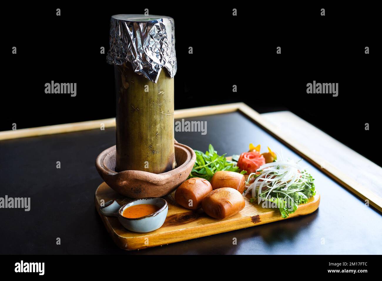 Stufato di manzo con verdure e pane mi banh su tagliere di legno isolato su sfondo nero Foto Stock