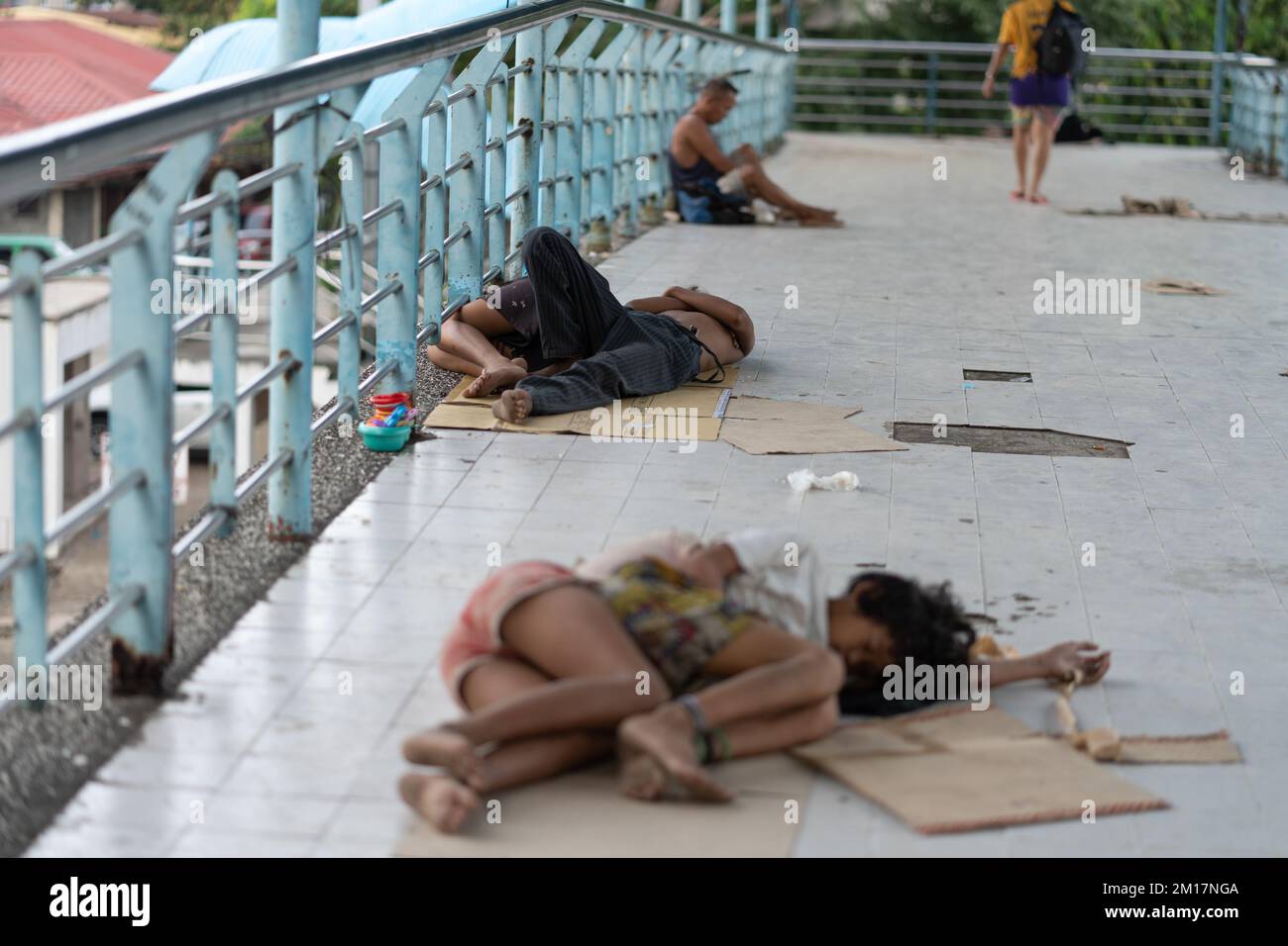 I bambini senza casa su un flyover che dormono su cartone usato come lettiera di fortuna, Cebu City, Filippine Foto Stock