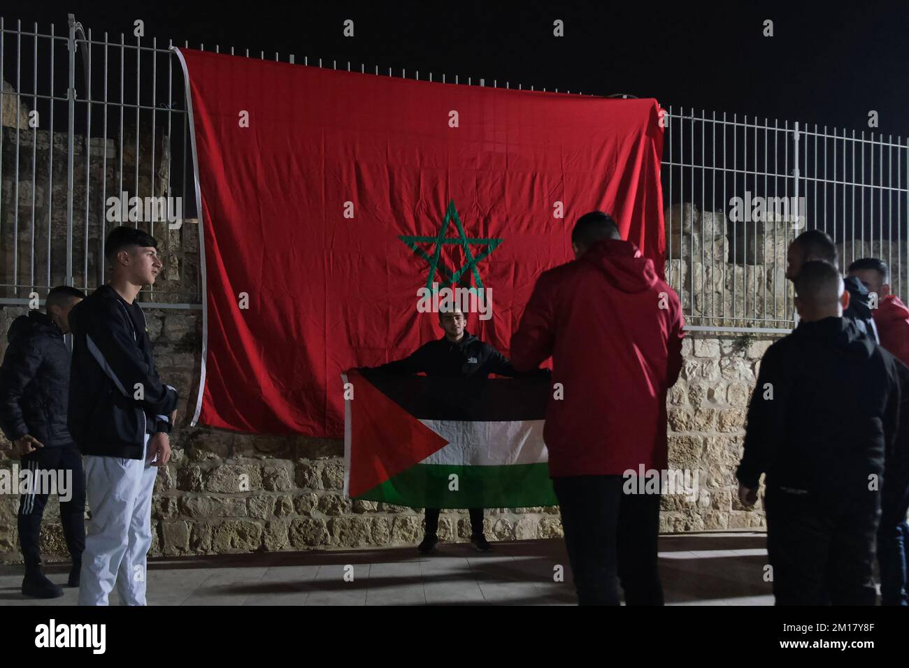 GERUSALEMME, ISRAELE - 10 DICEMBRE: I giovani palestinesi posano con una bandiera marocchina e palestinese, mentre celebrano la vittoria del Marocco contro il Portogallo dopo la Coppa del mondo FIFA Qatar 2022 Quarter Final Match tra Marocco e Portogallo, nella città vecchia il 10 dicembre 2022 a Gerusalemme, Israele. Il Marocco diventa il primo lato africano ad entrare nella semifinale della Coppa del mondo FIFA dopo il Portogallo in Qatar. Credit: Eddie Gerald/Alamy Live News Foto Stock