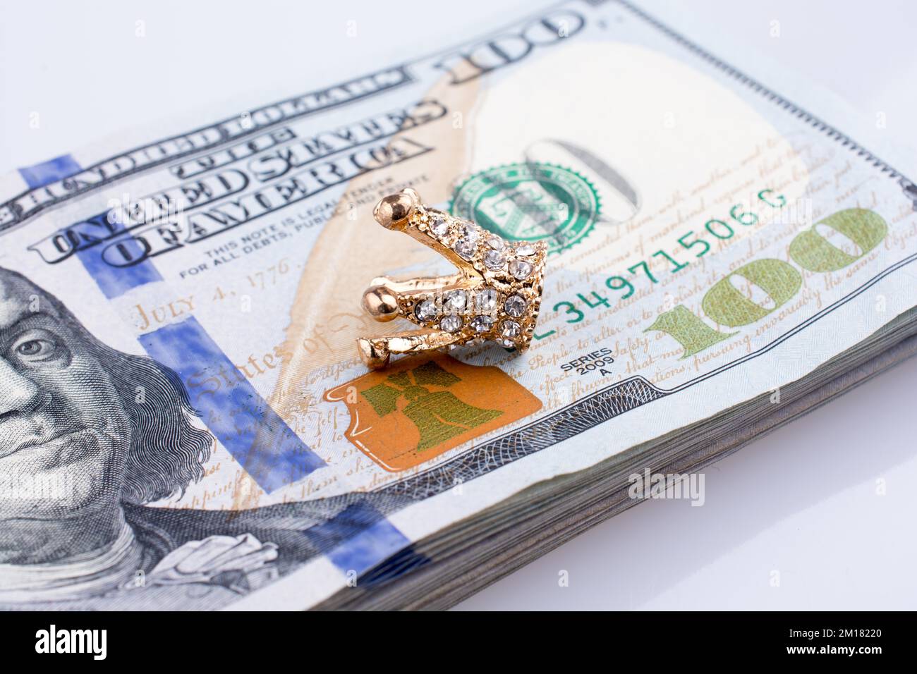 Banconote americane da 100 dollari e una corona color oro Foto Stock