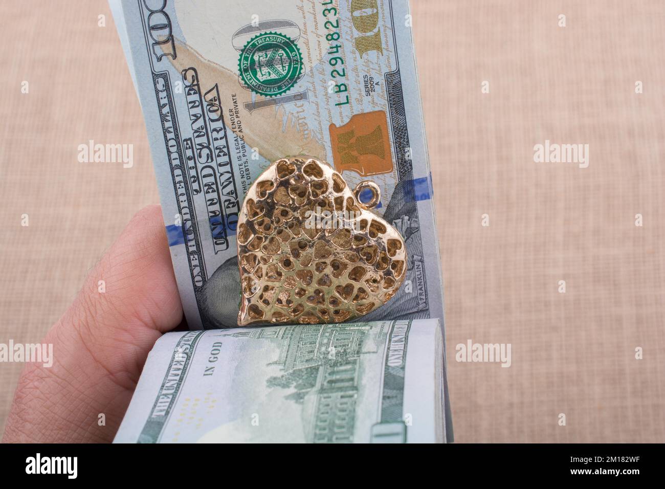 American 100 banconote di dollari con un clip di cuore in mano Foto Stock