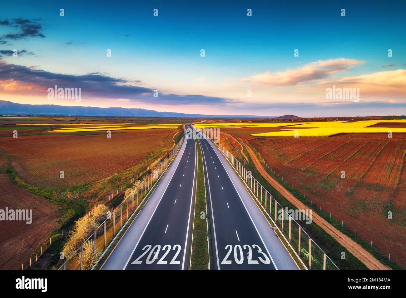 Veduta aerea dell'autostrada al tramonto di 2022 anno e di nuovo anno 2023. Trasporti, logistica e agricoltura Foto Stock