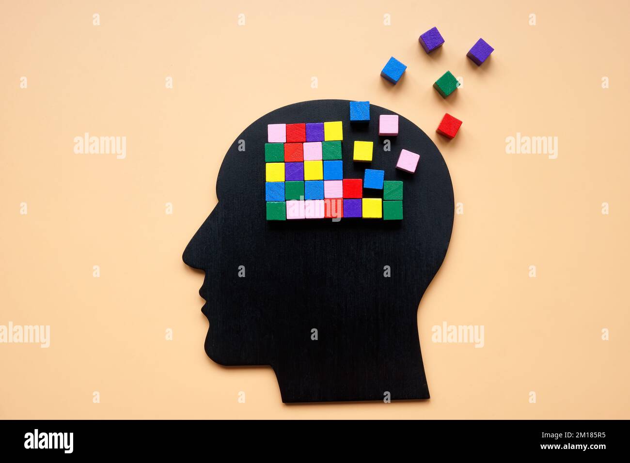 Una testa con cubi colorati, parte dei quali è persa come simbolo di demenza. Foto Stock