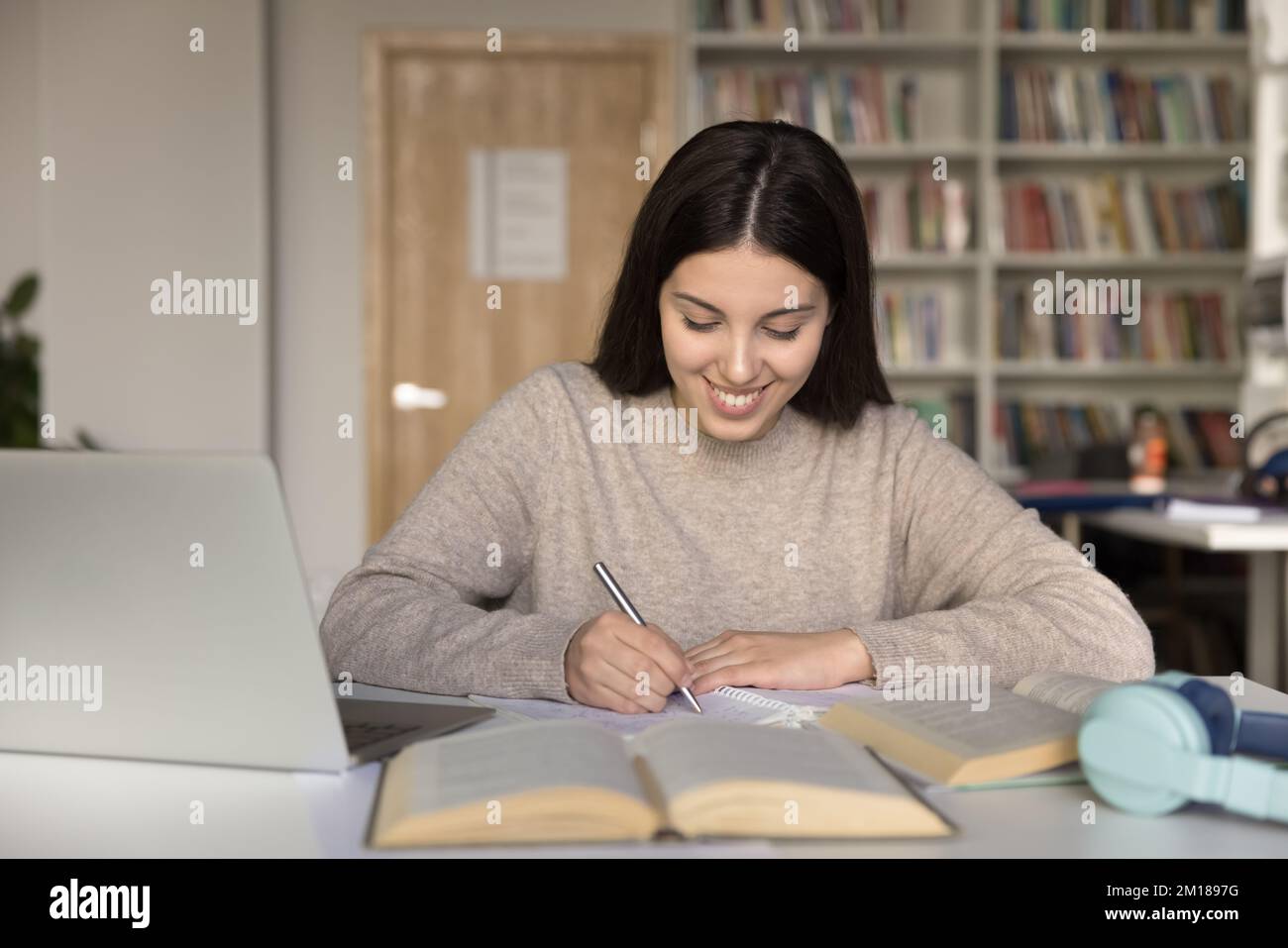 Happy Hispanic piuttosto femmina studente di studio, facendo i compiti a casa Foto Stock