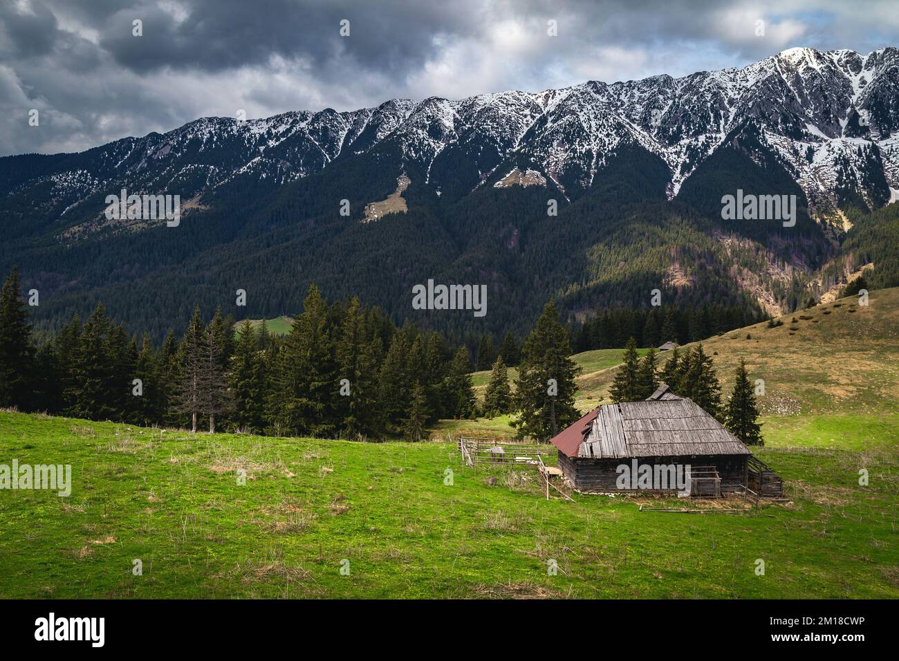 Spettacolare località rurale alpina con capanna di legno riccamente e alta neve Piatra Craiului montagne, Pestera villaggio, Transilvania, Romania, Europa Foto Stock