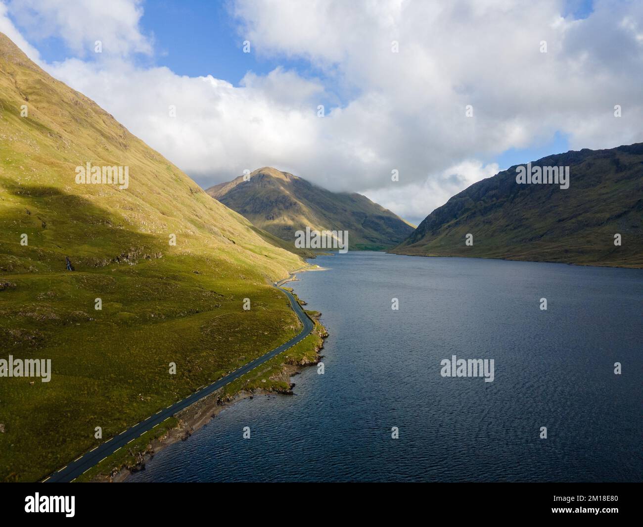 Irlanda, Doolough Valley. Luce del giorno ripresa con contrasto tra la strada gialla e le montagne. Wild Atlantic Way. Foto Stock