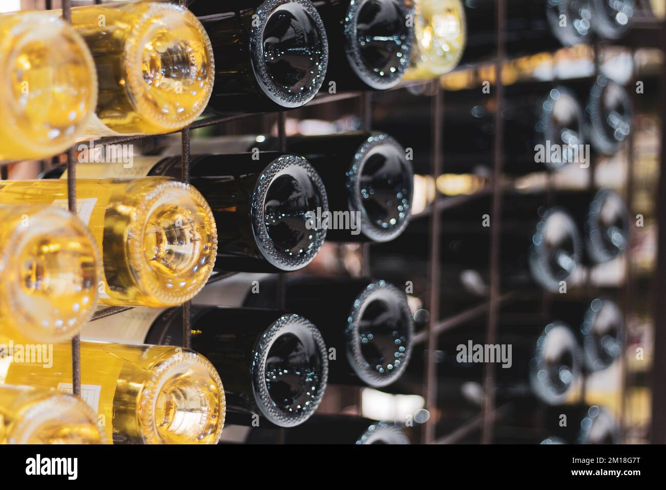 Bottiglie di vino in cantina. Bottiglie di vino bianco e rosso nel seminterrato della cantina. Collezione di vini di lusso. Bevande alcoliche sfondo. Varietà di vini. Foto Stock