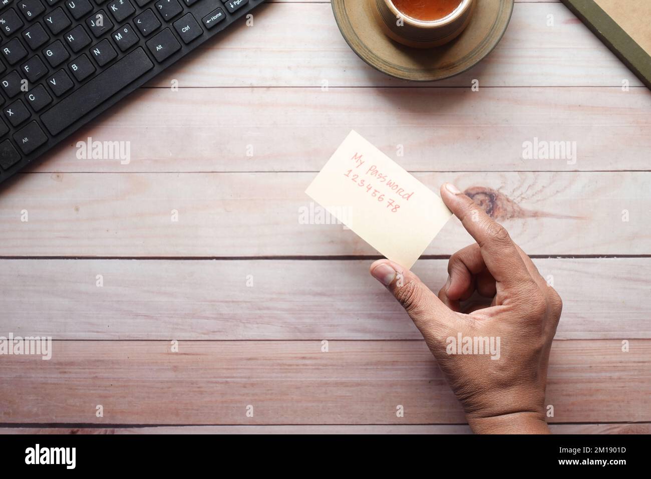 tenendo una carta mano scrivere il testo della password Foto Stock