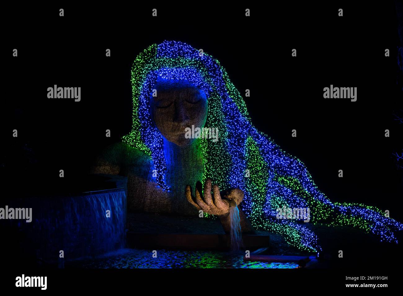 Una bella statua di madre natura con i suoi capelli illuminati da luci di Natale Foto Stock
