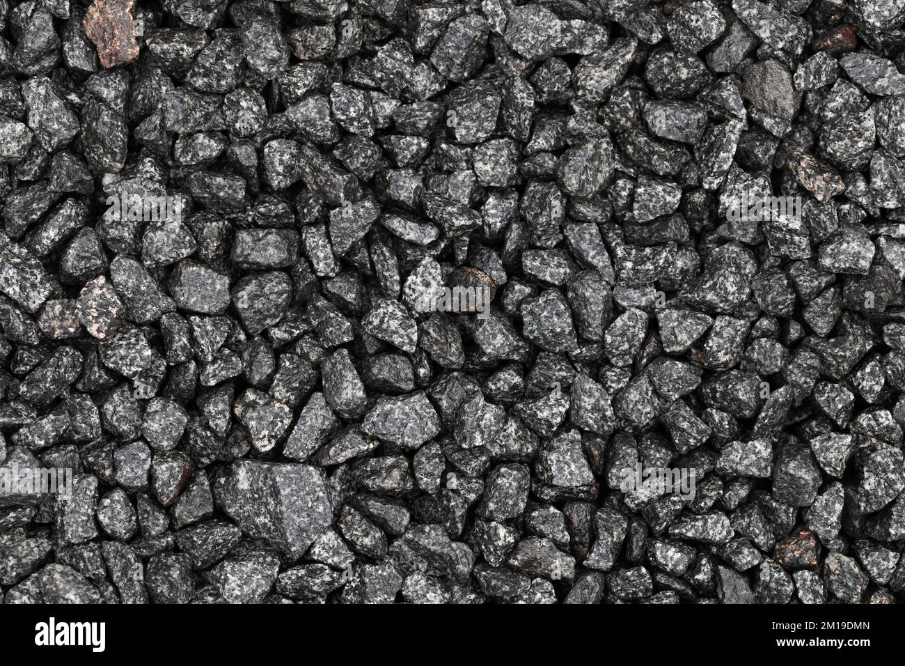 Ghiaia umida grigio scuro che copre il terreno in cantiere, vista dall'alto. Texture foto di sfondo Foto Stock