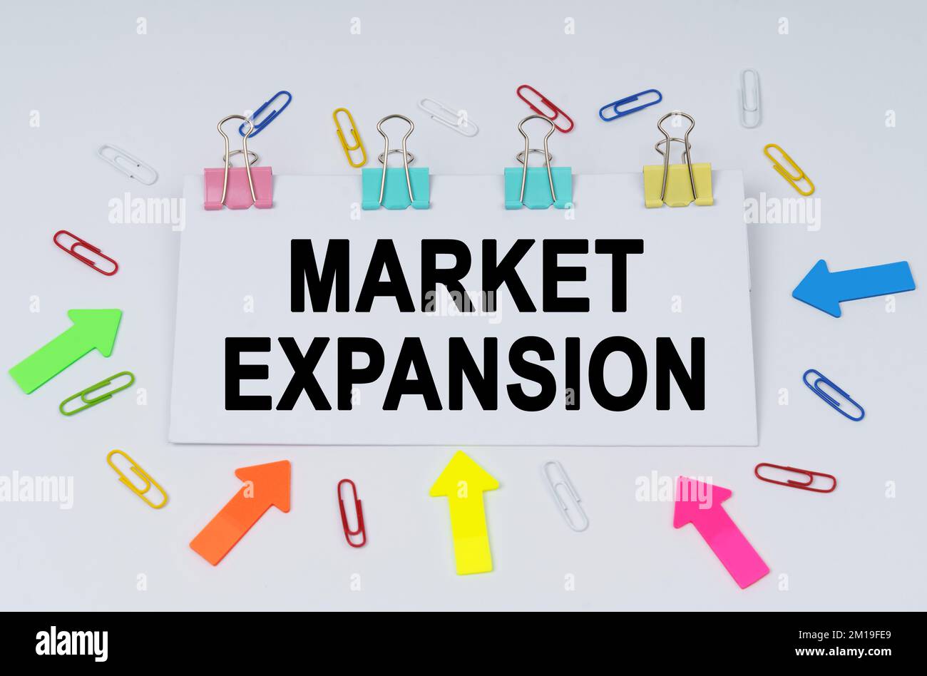 Concetto di business e finanza. Sulla tabella ci sono graffette e frecce direzionali, un segno che dice - espansione del mercato Foto Stock
