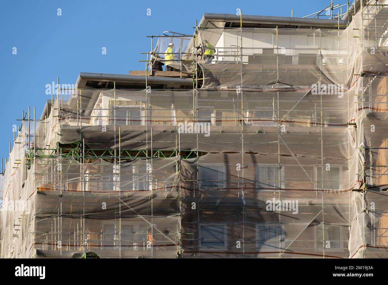 Appartamenti di alto livello su Winterthur Way, Basingstoke, dicembre 2022. Stanlil contoterzisti che rimuovono i pannelli di rivestimento e la piallatura dei balconi a causa della sicurezza antincendio. REGNO UNITO Foto Stock