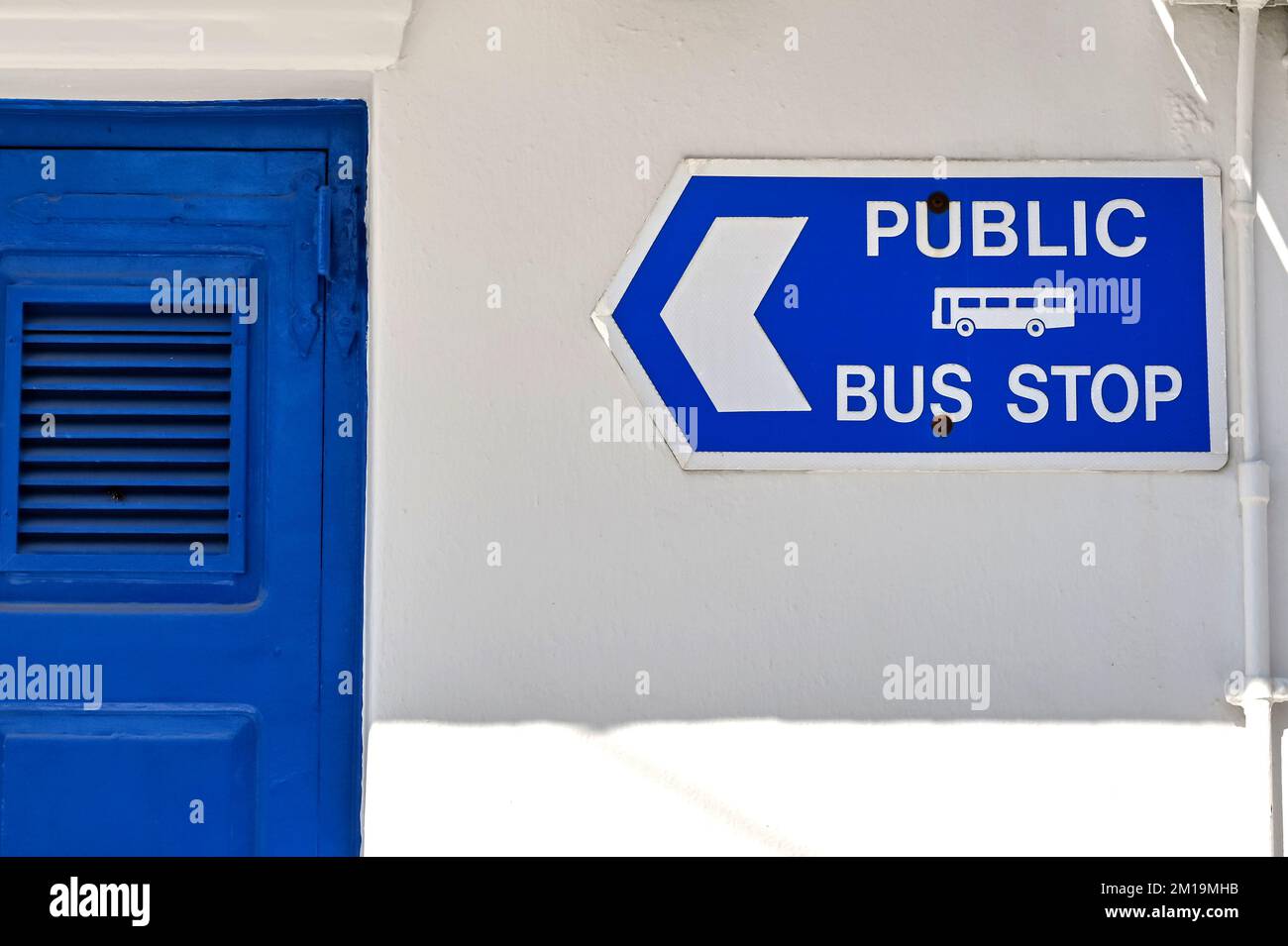 Cartello sulle pareti di un edificio dipinto di bianco che mostra ai visitatori la strada per la fermata dell'autobus. Nessuna gente Foto Stock