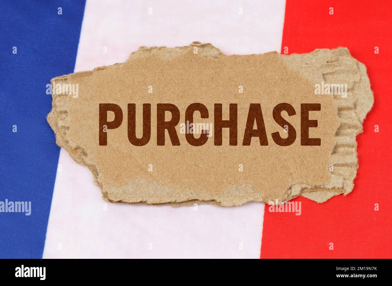 Concetto di business e finanza. Sullo sfondo della bandiera francese si trova cartone con l'iscrizione - acquisto Foto Stock