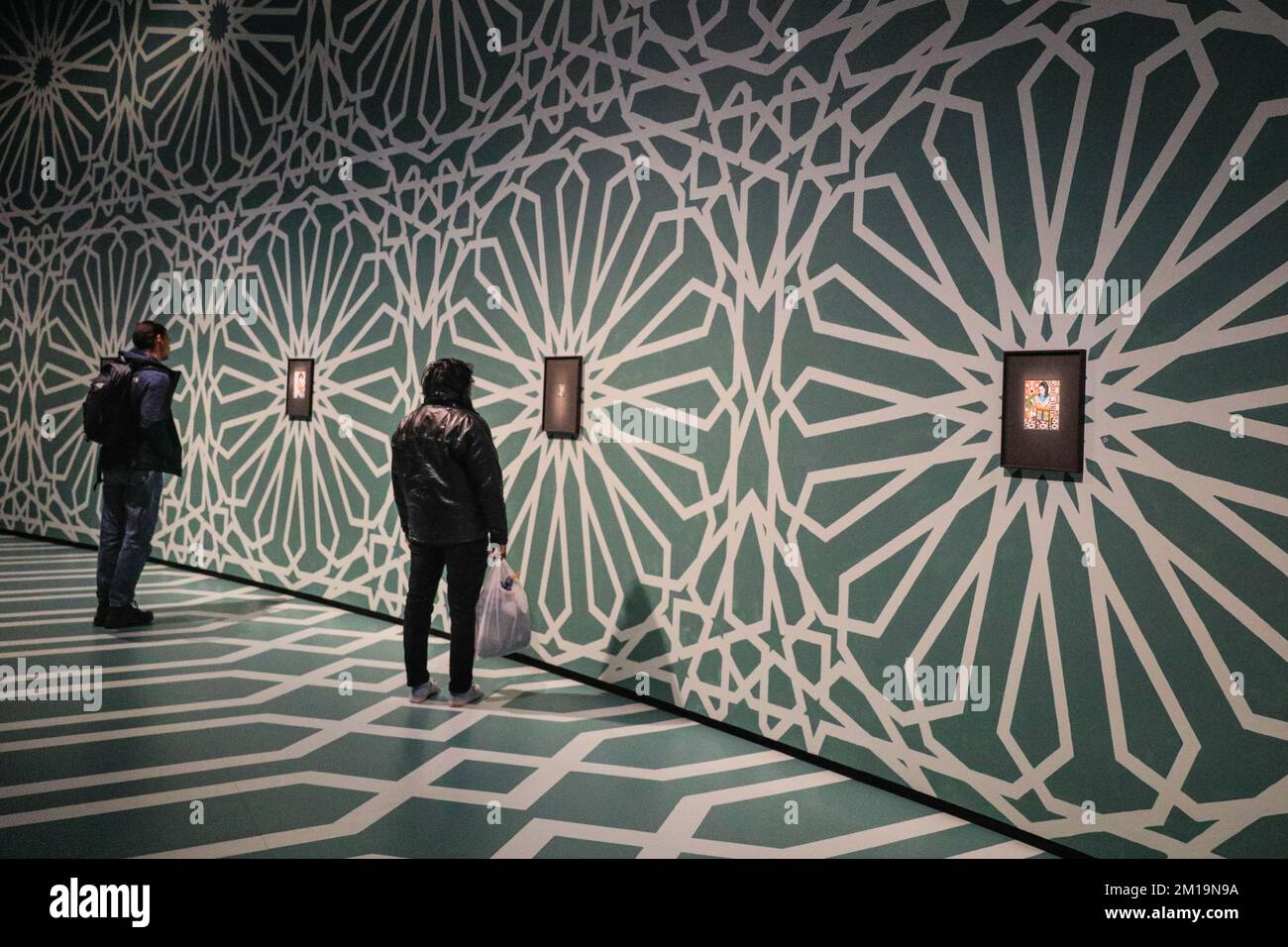 Londra, Regno Unito. 11th Dec, 2022. I visitatori guardano le opere esposte. Lo spazio Curve del Barbican è stato trasformato in una galleria immersiva con pavimenti e soffitti dipinti a mano in motivi islamici per la mostra Soheila Sokhanvari 'Rebel Rebell'. L'artista iraniano raffigura figure culturali iraniane in colorati ritratti in miniatura, mostrando la contraddizione tra la vita delle donne iraniane tra la rivoluzione del 1920s e del 1979. La mostra è gratuita e fino al 26 febbraio 2023. Credit: Imageplotter/Alamy Live News Foto Stock
