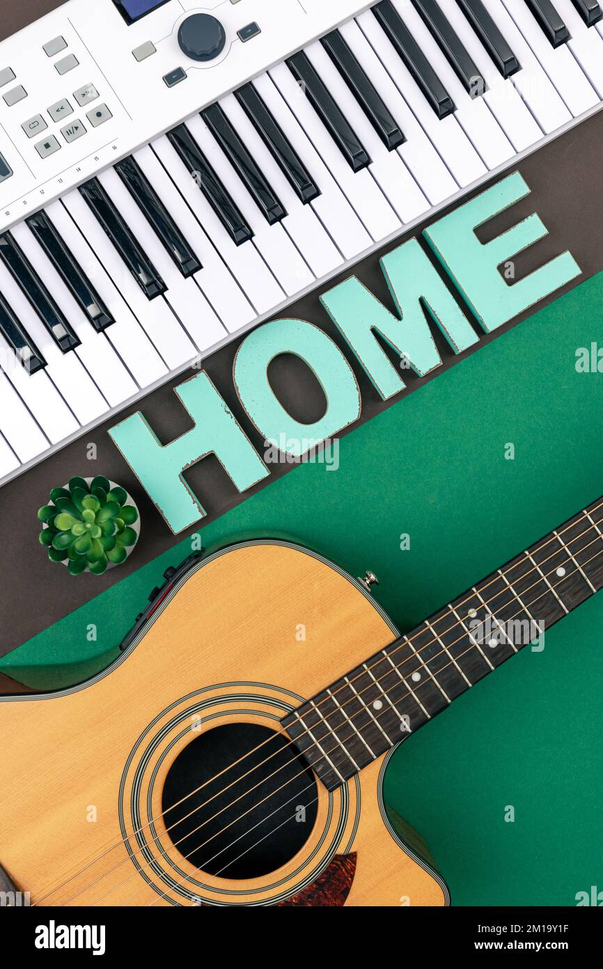 Tasti musicali, chitarra e parola decorativa a casa su uno sfondo colorato. Foto Stock