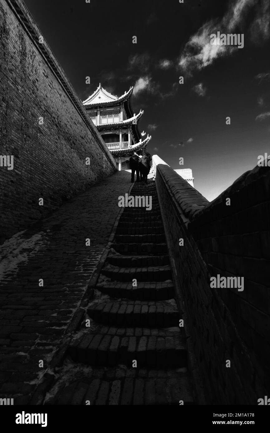 Jiayuguan City Tower, Gansu, Cina, i mattoni delle mura della città sembrano molto storici sotto l'effetto della luce del sole e delle ombre Foto Stock