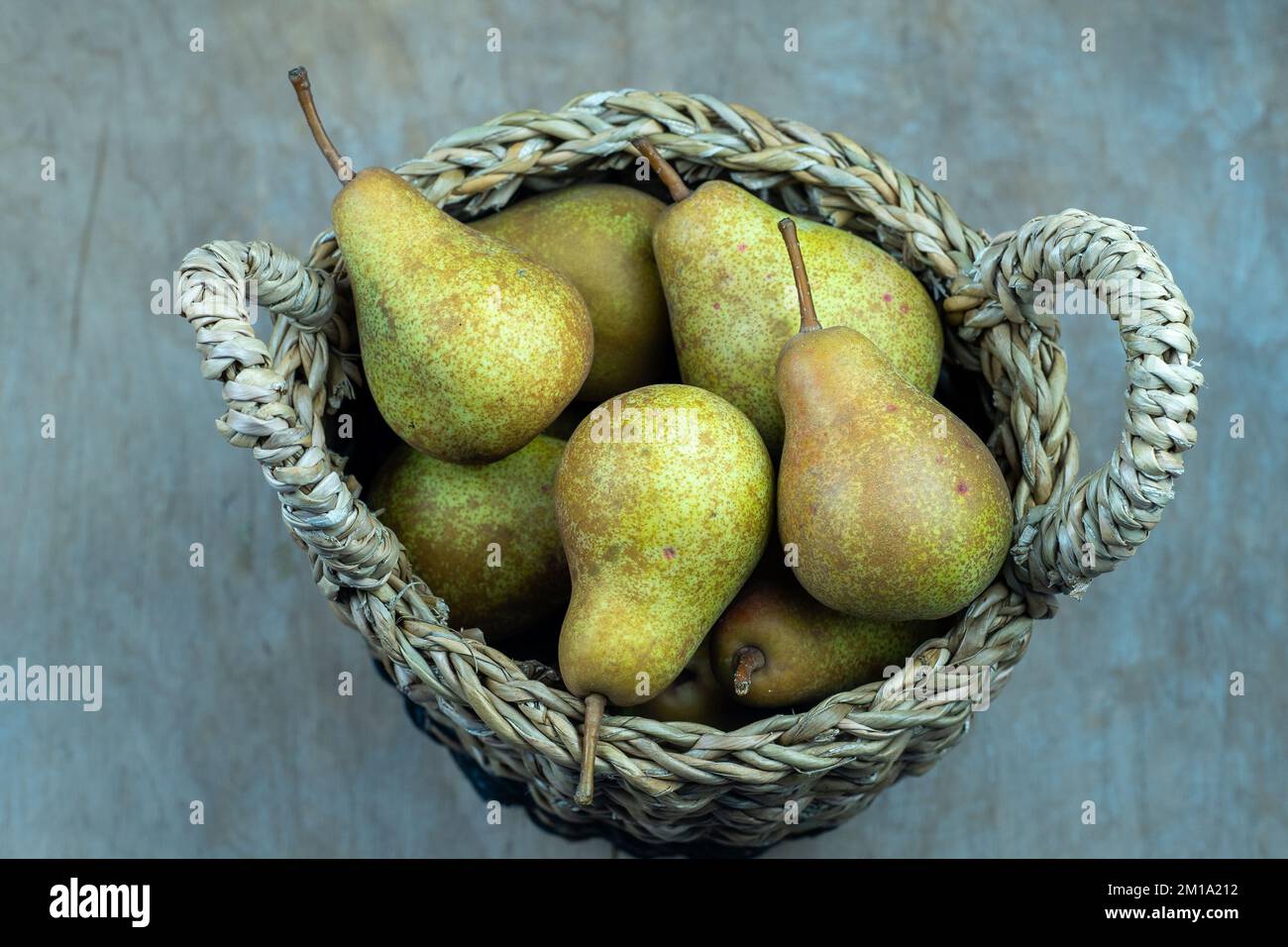 Pere in cesto su uno sfondo di legno. Raccolta di frutta. Autunno ancora vita. Pear Variety Bera Conference. Cibo vitaminico. Foto Stock