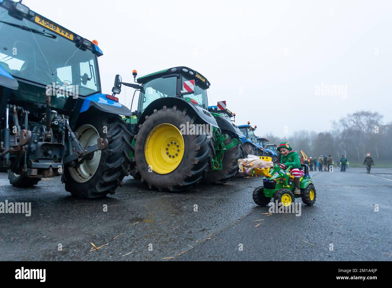 Bridgnorth, Shropshire, Regno Unito. 11th Dec, 2022. Un ragazzino guida il suo trattore giocattolo tra i trattori reali di dimensioni reali che si sono riuniti per il Bridgnorth Festive Charity Tractor Run 2022. Oltre 100 trattori agricoli formarono una processione e guidarono attraverso i villaggi di Shropshire dal mercato del bestiame di Bridgnorth per raccogliere denaro per Hope House Children's Hospices. Credit: Peter Lopeman/Alamy Live News Foto Stock