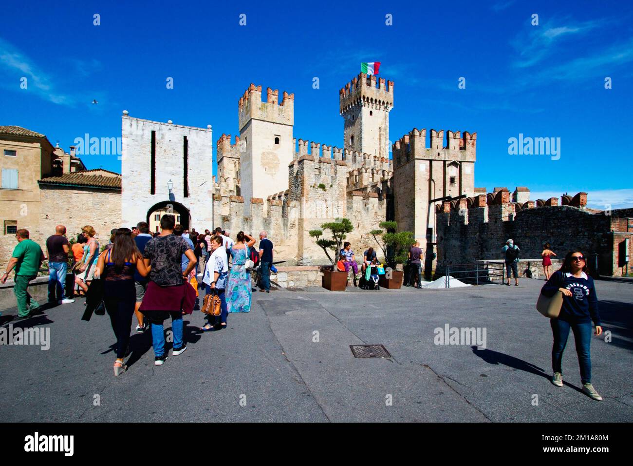 Persone nella piazza di fronte al castello d'acqua Scaligero nella città di Sirmione sul Lago di Garda in Italia. Foto Stock