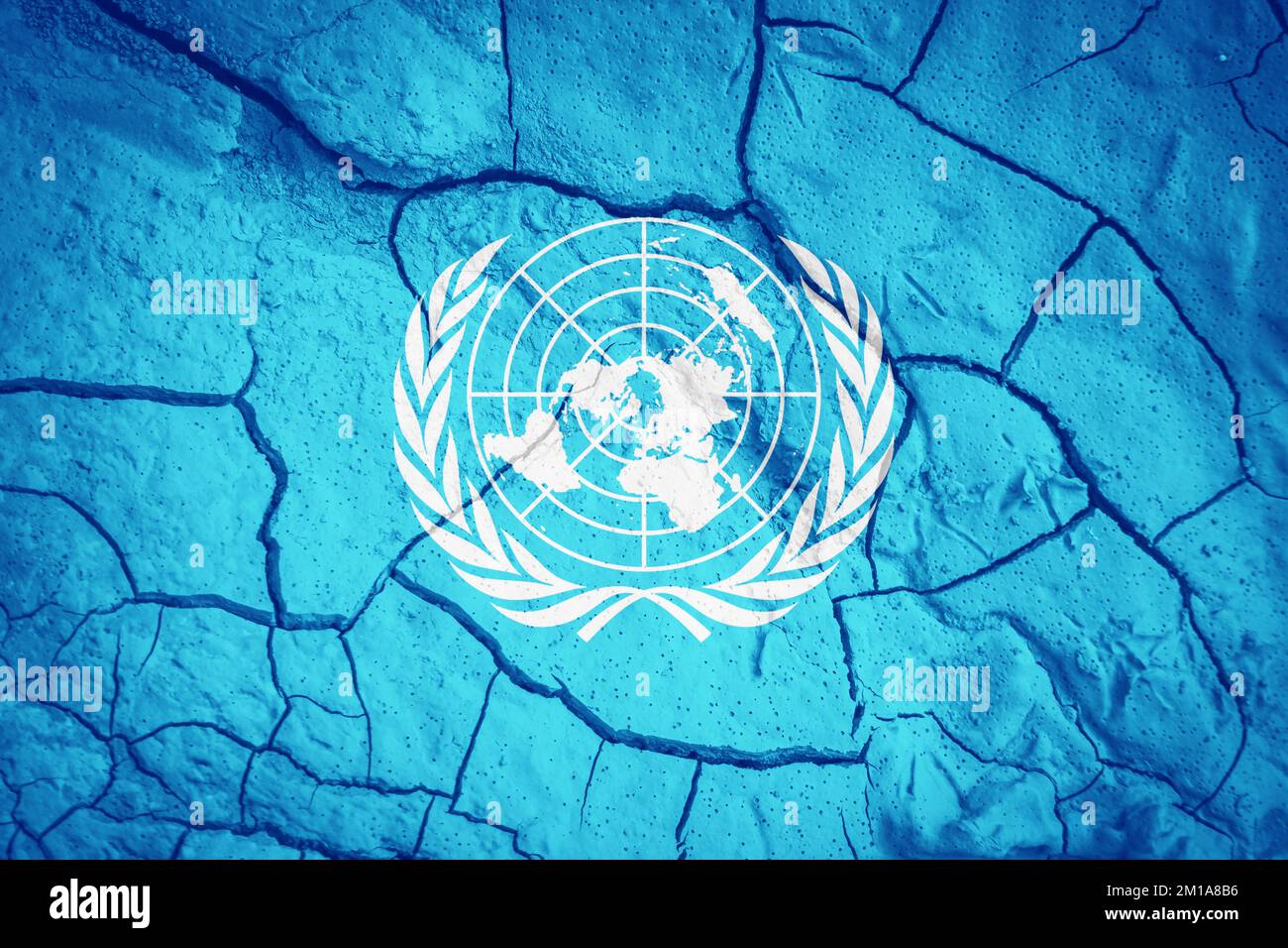 Bandiera delle Nazioni Unite. Bandiera delle Nazioni Unite. Simbolo un. Bandiera sullo sfondo di terra secca spaccata Bandiera con concetto di siccità Foto Stock