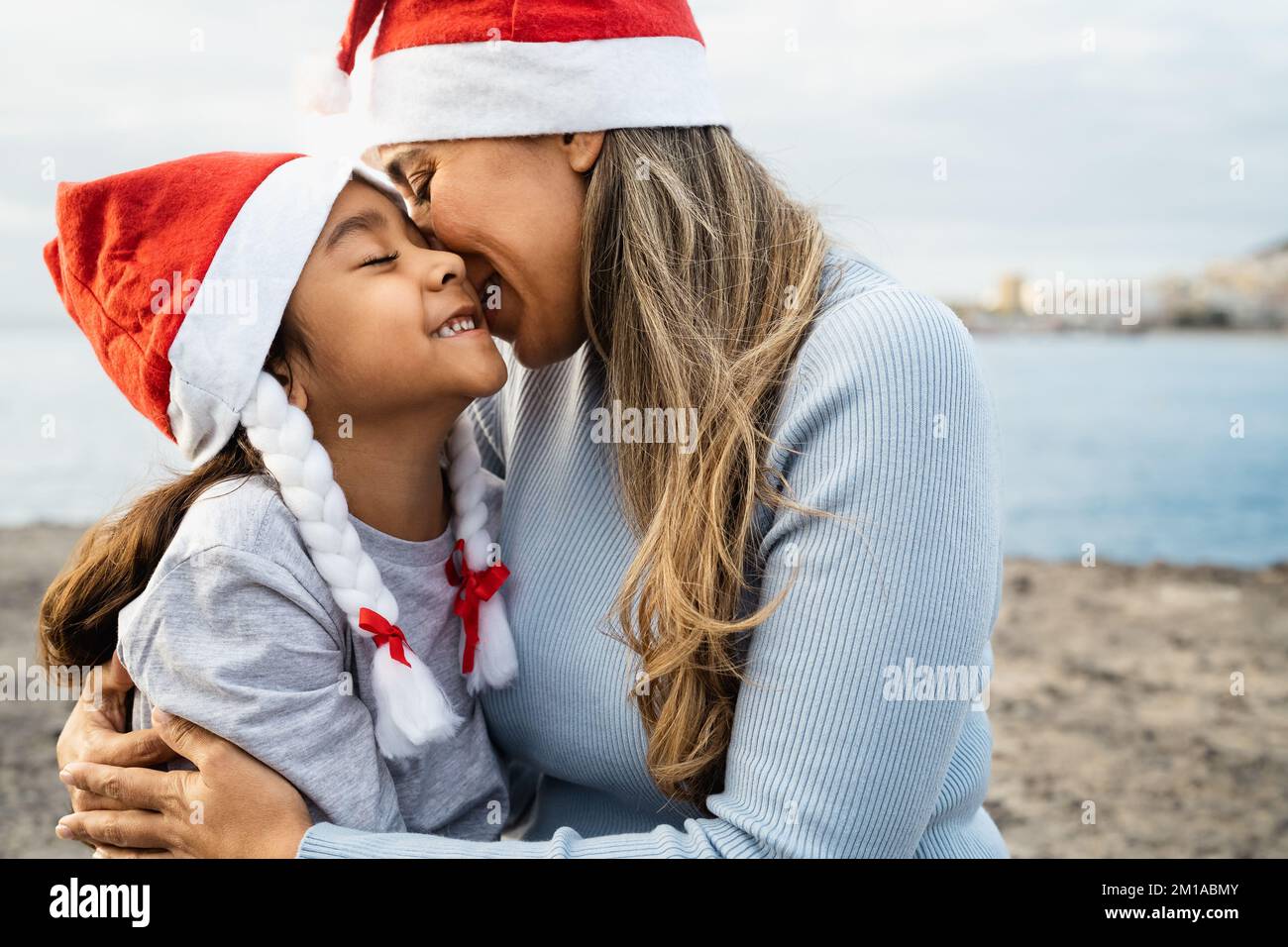 Felice madre latina che ha un tenero momento con il suo bambino durante le vacanze di Natale - concetto di famiglia e di vacanza Foto Stock