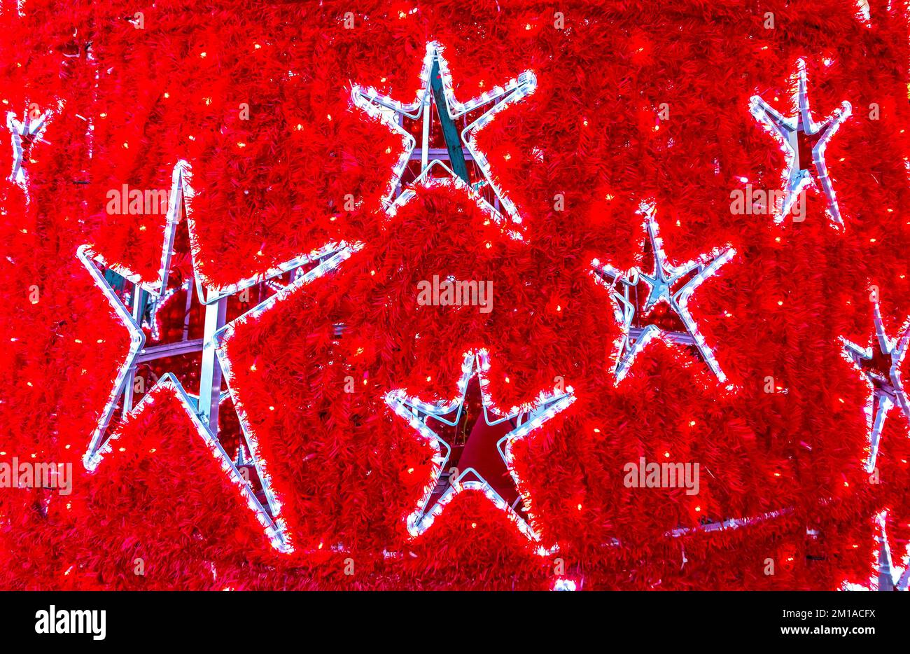 Forme a stella su un albero di Capodanno decorato in rosso. Dettagli ravvicinati delle decorazioni natalizie Foto Stock