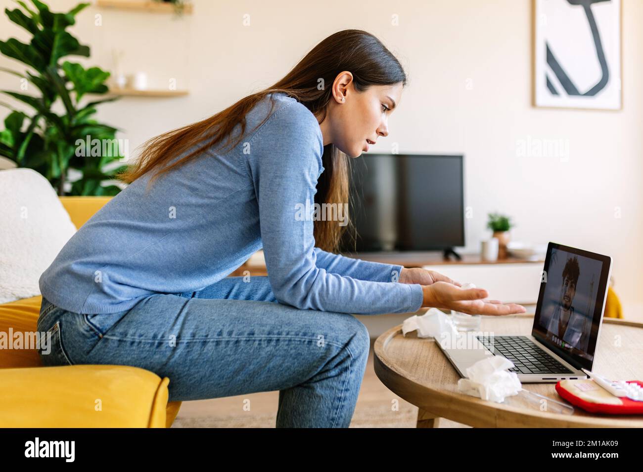 Donna che parla con il medico attraverso la consultazione medica sulla videochiamata laptop Foto Stock