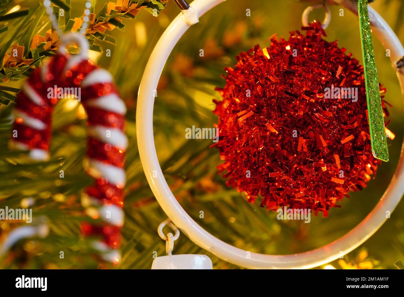 Le decorazioni e gli ornamenti dell'albero di Natale si chiudono in macro mostrando la bellezza dell'albero di Natale ed è ornamenti rossi di festa di contrasto Foto Stock