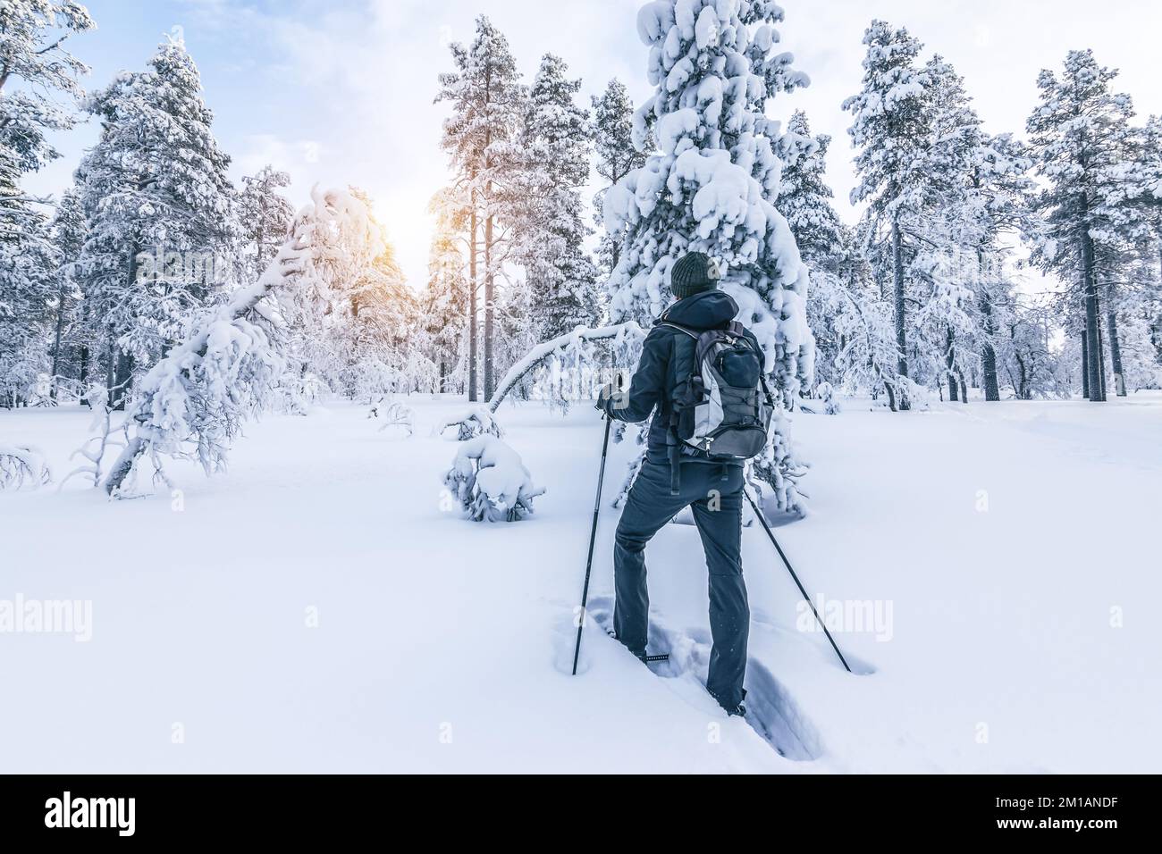 Escursionista con racchette da neve che cammina sulla neve. Sport invernali all'aperto e concetto di stile di vita sano. Foto Stock