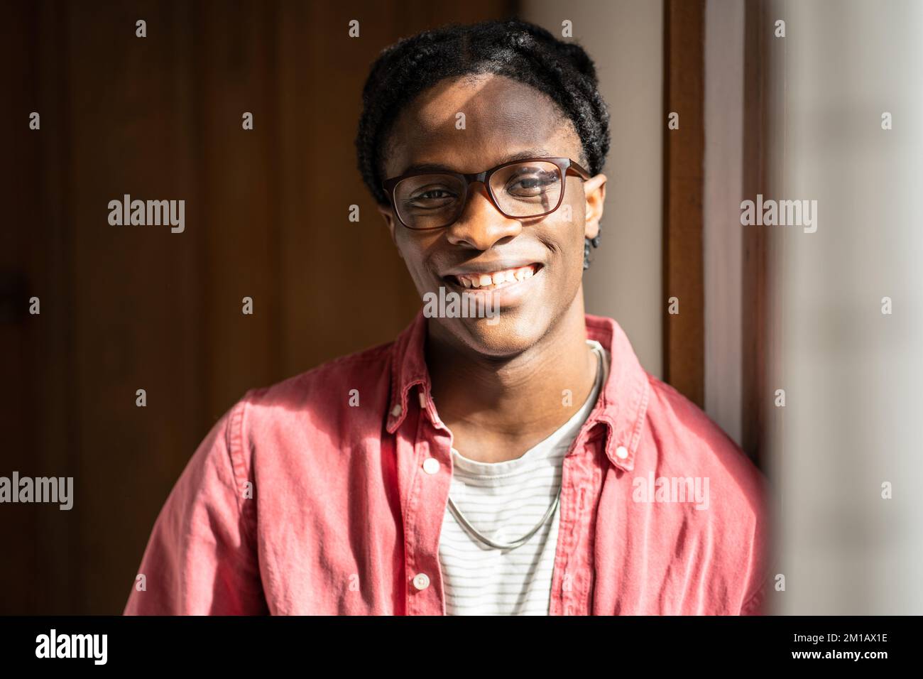 Felice ottimista giovane afroamericano ragazzo in piedi a casa esprimere emozioni positive Foto Stock