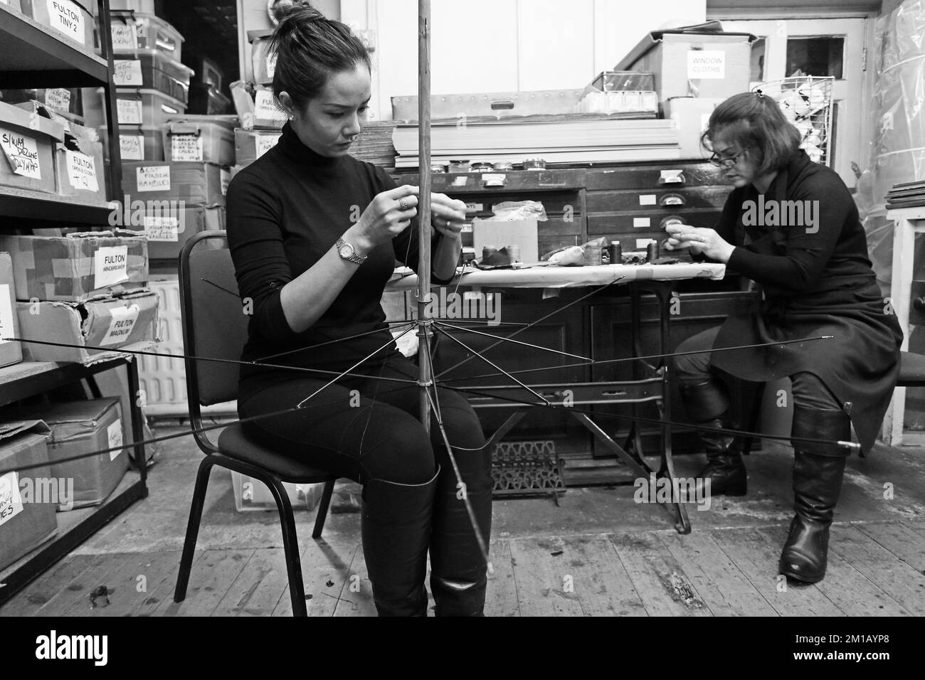 Marinai che lavorano sull'ombrello a James Smith & Sons . Fare ombrello tradizionale nel loro laboratorio, a Londra, Inghilterra Foto Stock