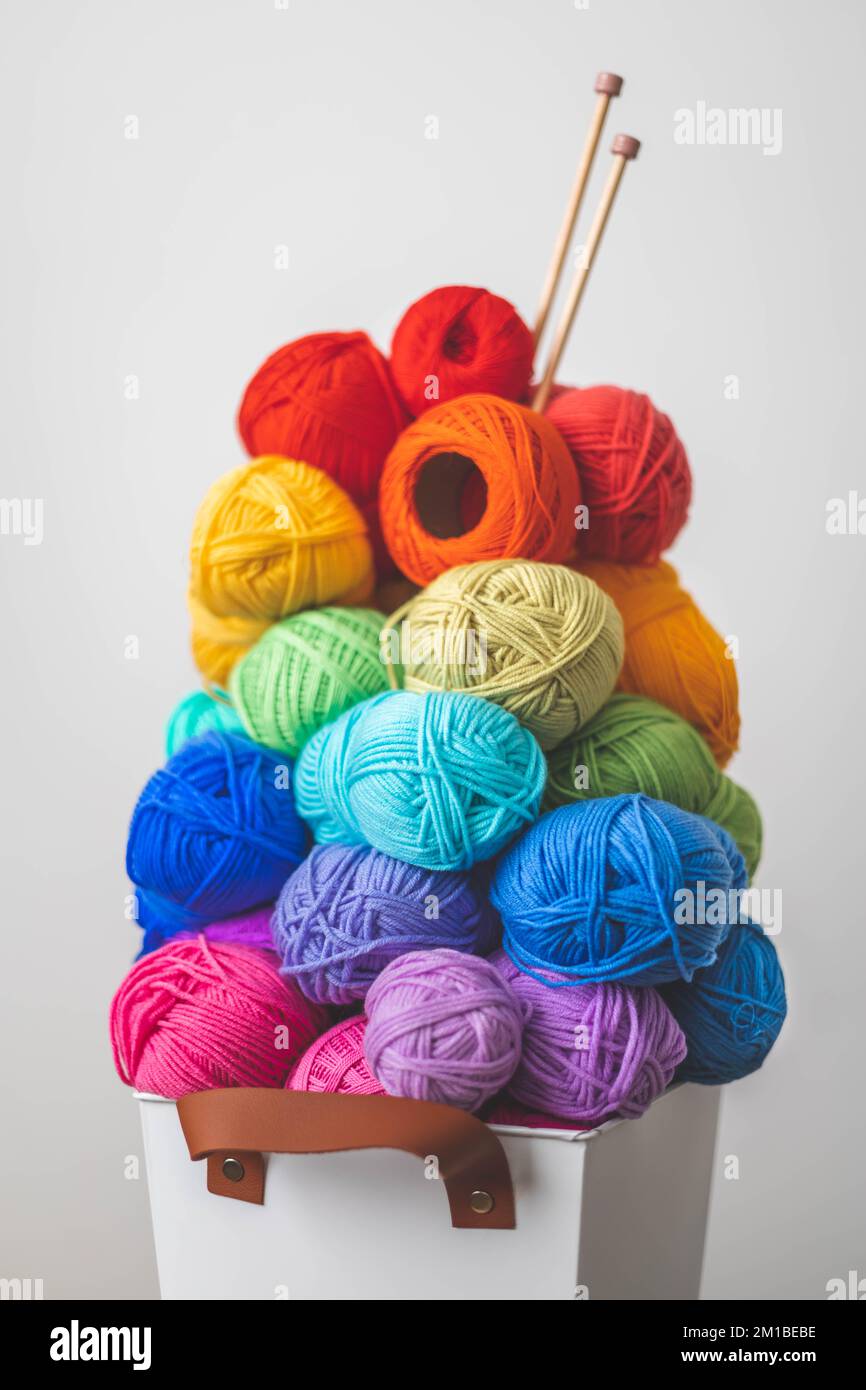 Tanti fili luminosi e colorati per lavorare a maglia e uncinetto in un  elegante cestino in stile scandi. Atmosfera accogliente e familiare Foto  stock - Alamy