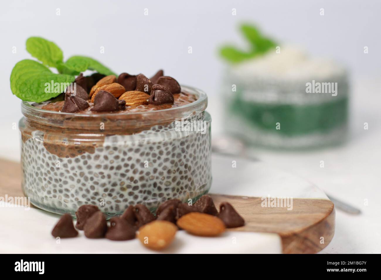 budino di chia con cioccolato e mandorle su tavolo bianco Foto Stock