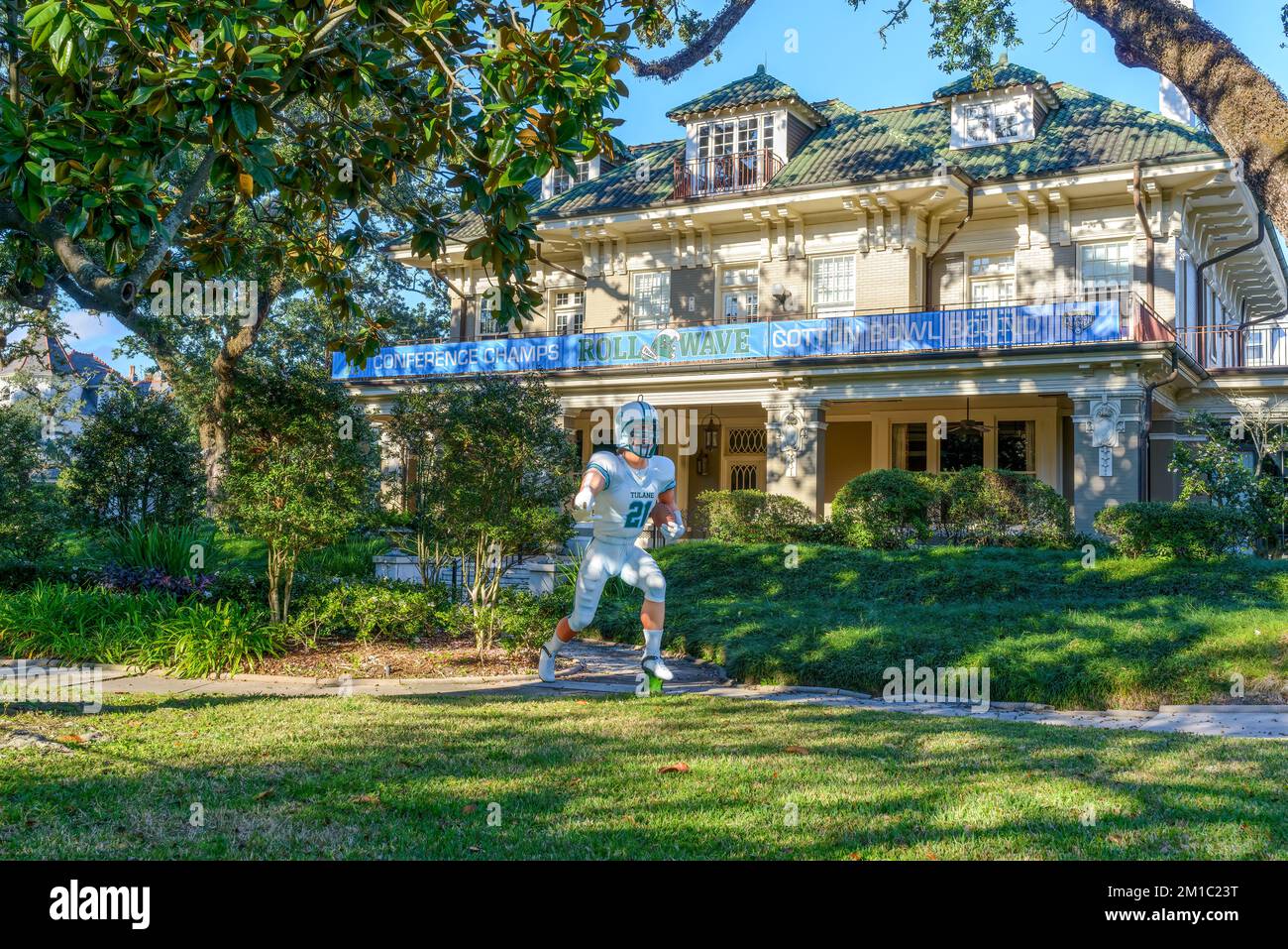 NEW ORLEANS, LA, USA - 10 DICEMBRE 2022: Cortile di St Charles Avenue Mansion con grande personaggio Tulane giocatore di calcio e banner sul balcone Foto Stock