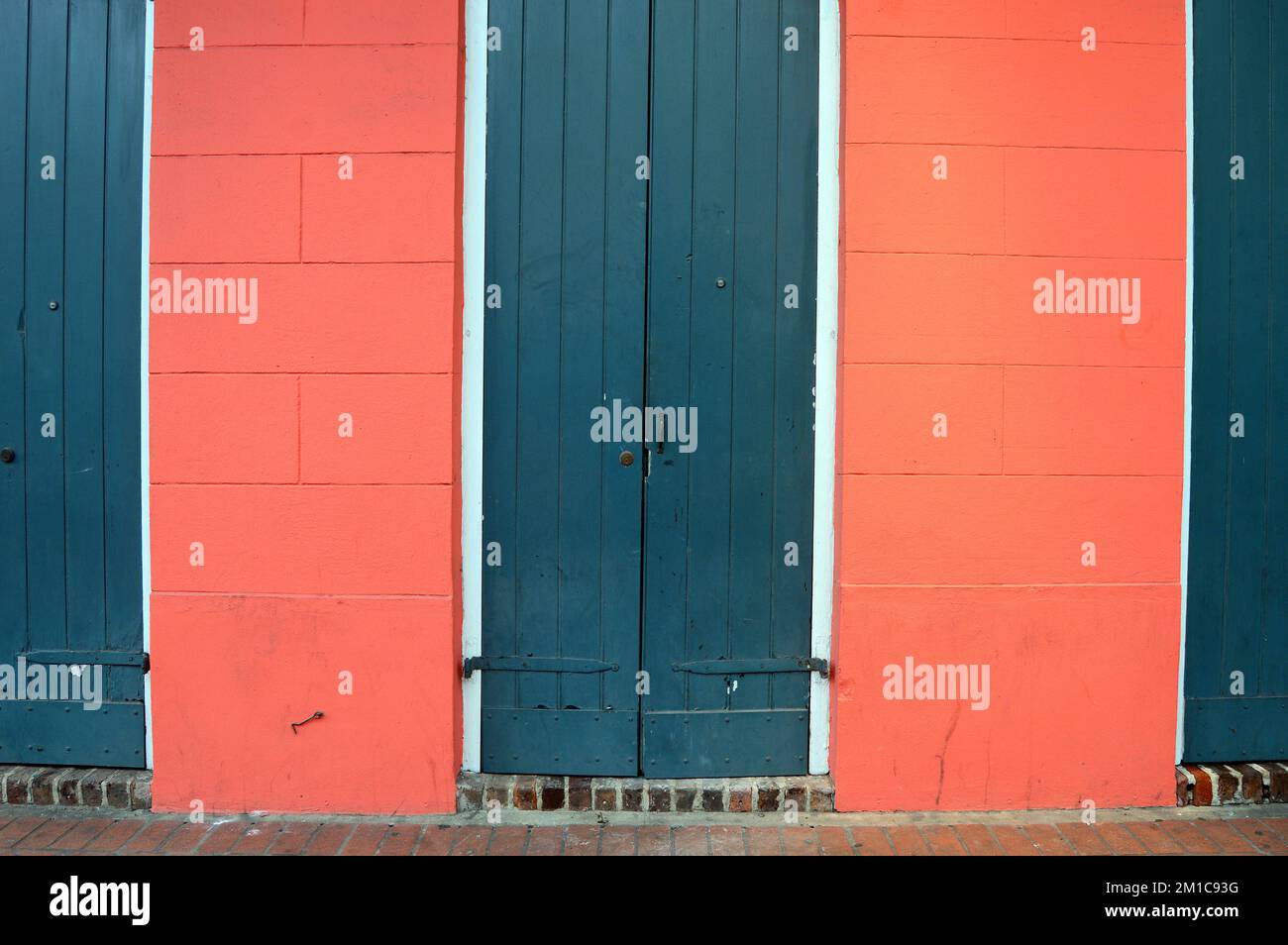 Le porte verdi contrastano con le pareti rosa scuro di una casa nel quartiere francese di New Orleans Foto Stock
