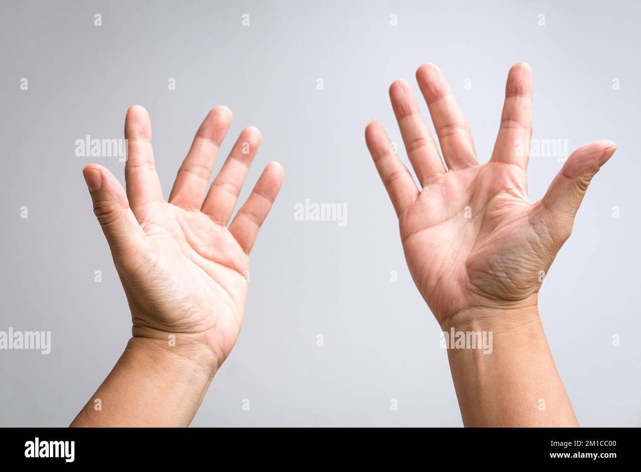 Coppia di mani maschili che si alzano e si allungano. Preghiera, adorazione o grida di aiuto. Foto Stock