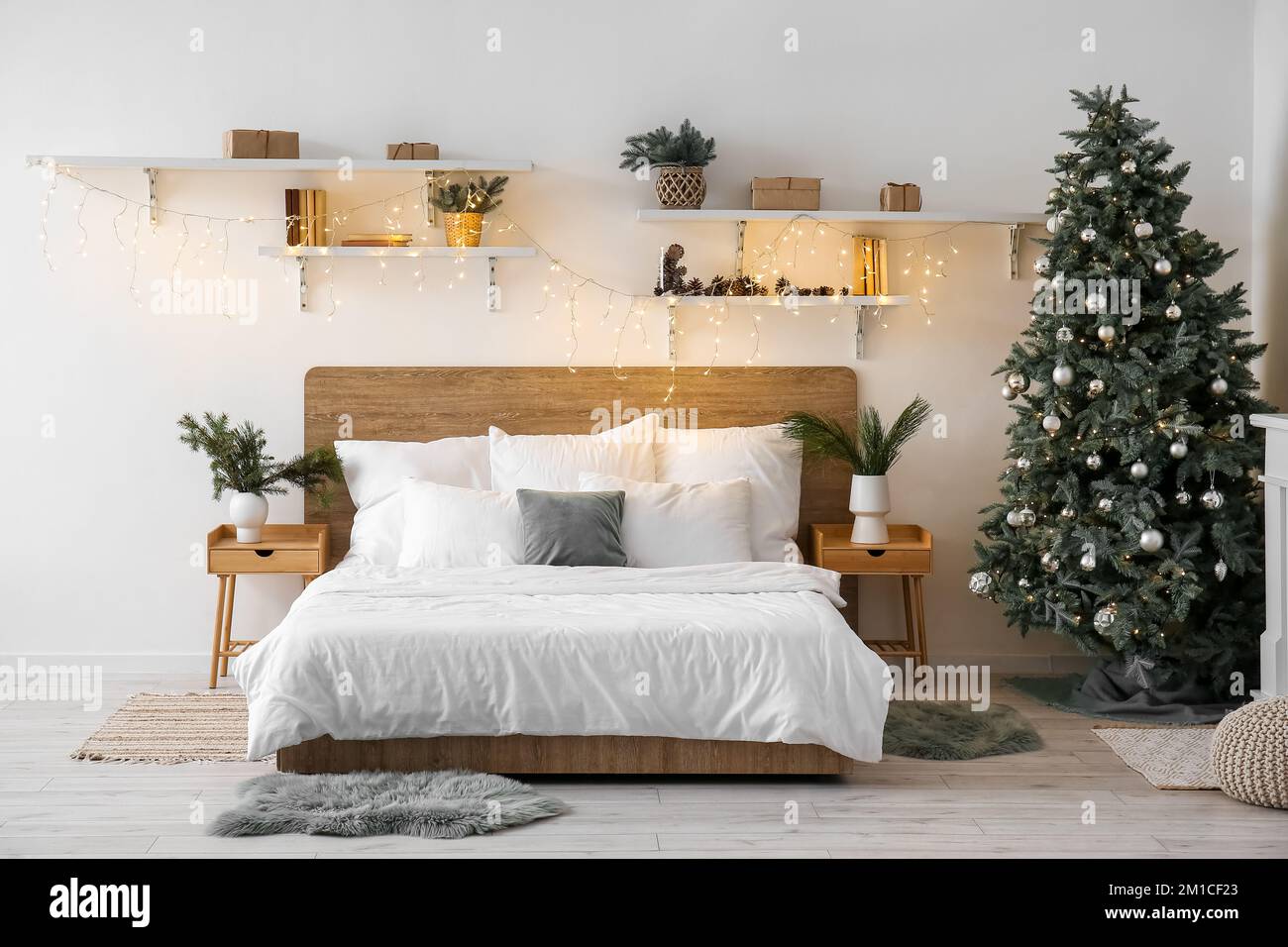 Interno della camera da letto con albero di Natale, mensole e luci  incandescenti Foto stock - Alamy