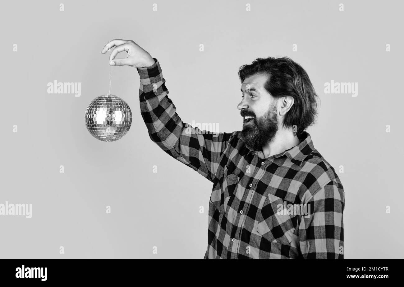 divertimento. lascia andare a ballare. festeggiamo la festa. uomo in camicia a scacchi con palla da discoteca. ragazzo casual esprime emozioni umane. happy hipster Foto Stock